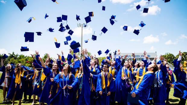 High school students throw their caps in the air of graduation.